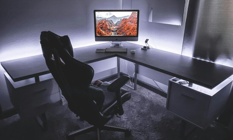 Sleek office desk setup featuring a gaming chair and widescreen monitor, ideal for productivity and gaming.
