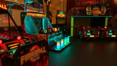 Colorful neon-lit arcade with various game machines including Fireball and Dinosaur Era.
