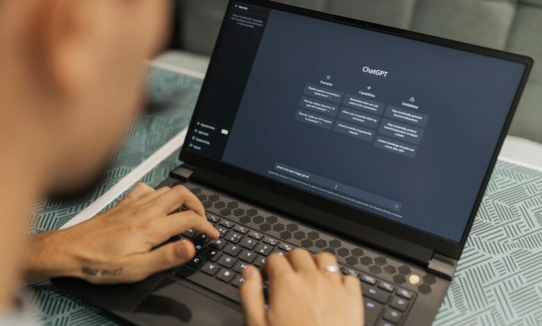 Close-up of a person typing on a laptop displaying the ChatGPT interface, emphasizing modern technology use.