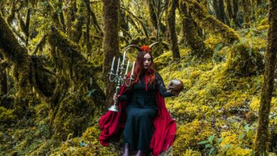 A mystical forest witch holding a candelabra and skull in Choachí, Colombia.