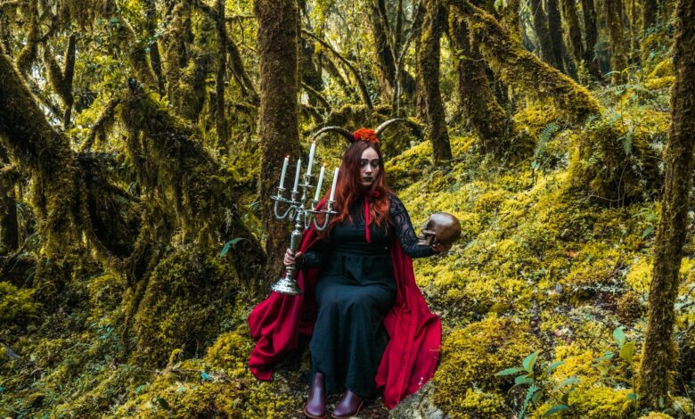 A mystical forest witch holding a candelabra and skull in Choachí, Colombia.