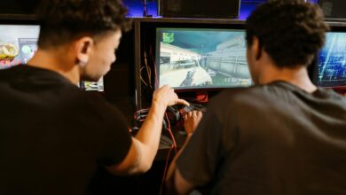 Two young men playing a multiplayer computer game at an arcade with enthusiasm and focus.