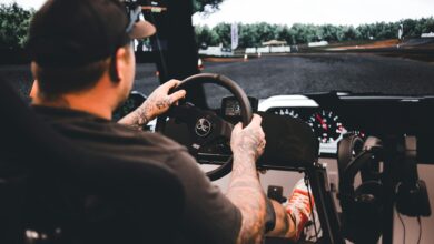 Focused gamer experiencing a detailed driving simulation setup indoors.