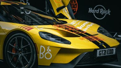 Dynamic close-up of a yellow sports car with vibrant graphics at a car show.