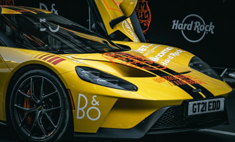 Dynamic close-up of a yellow sports car with vibrant graphics at a car show.