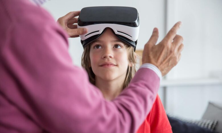 A young girl trying virtual reality goggles for the first time indoors with guidance.