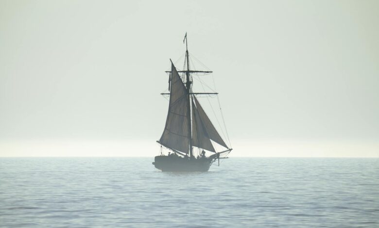 A tranquil silhouette of a sailing ship on a calm sea horizon, evoking peace and adventure.
