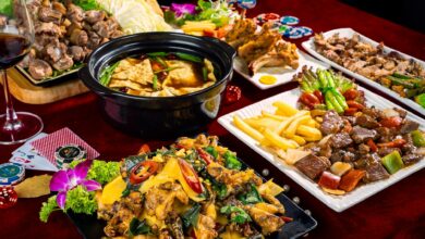 A vivid display of Asian cuisine featuring stir-fried dishes, hot pot, and poker-themed table setting.