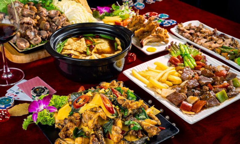 A vivid display of Asian cuisine featuring stir-fried dishes, hot pot, and poker-themed table setting.