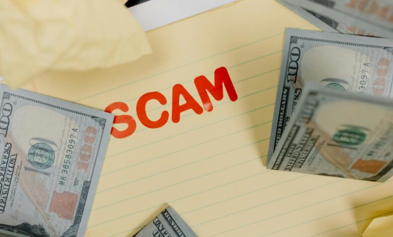 Conceptual image of financial scam with US dollars on yellow paper and word 'scam' visible.