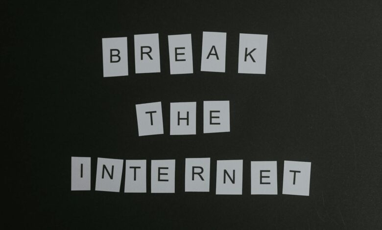 Conceptual flat lay of 'Break the Internet' message with white letters on a black background.