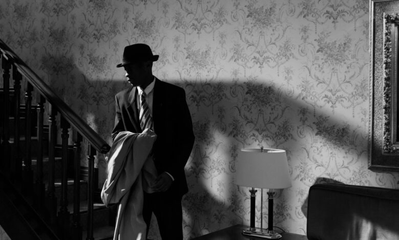 A black and white scene of a detective in a vintage interior, exuding mystery and intrigue.