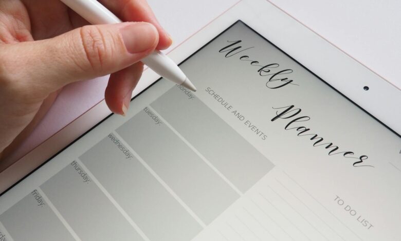 A stylus writing in a digital weekly planner on a tablet screen, ideal for organization.
