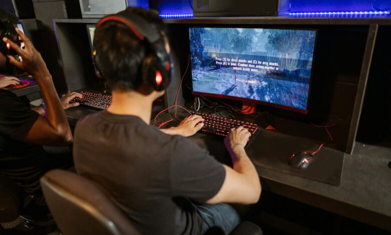 Two gamers immersed in a video game with high-tech equipment and vibrant gaming setup.