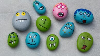 Vibrant hand-painted rocks with monster faces, perfect for creative Halloween crafts and indoor fun.