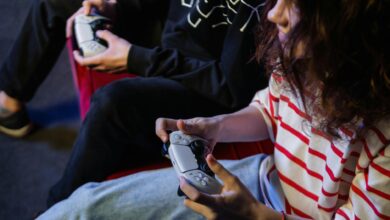 Two young gamers intensely focused while playing video games with modern controllers indoors.