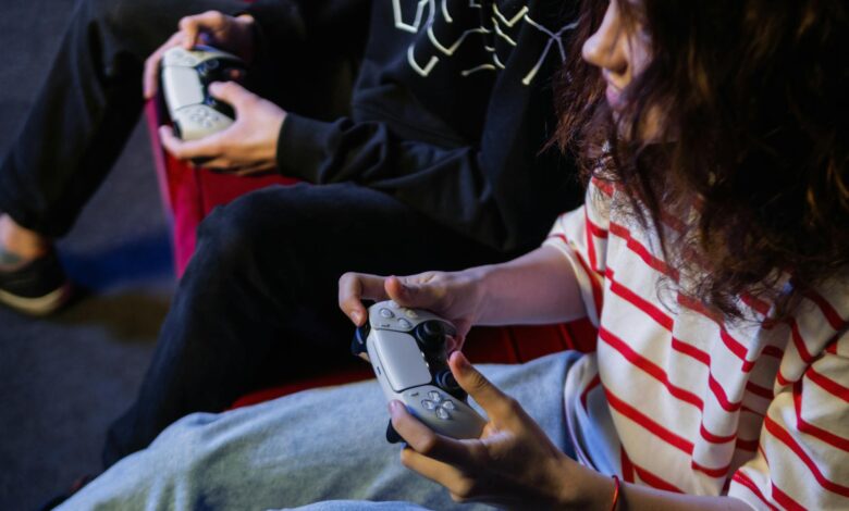 Two young gamers intensely focused while playing video games with modern controllers indoors.