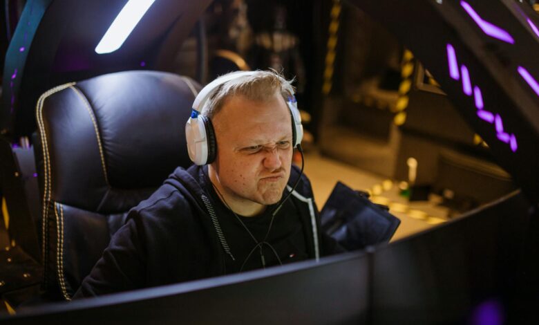 Focused gamer wearing headphones intensely playing an online esports game indoors.