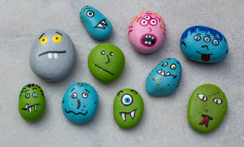 Vibrant hand-painted rocks with monster faces, perfect for creative Halloween crafts and indoor fun.