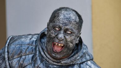 A person wearing a detailed stone statue costume with a scary expression in Kroměříž.