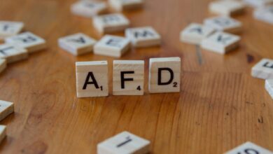 Close-up of scrabble tiles spelling 'AFD' on a wooden table surface, symbolizing political concepts.