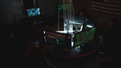 Team of cybersecurity experts collaboratively working on data protection in a dimly lit room filled with computers.