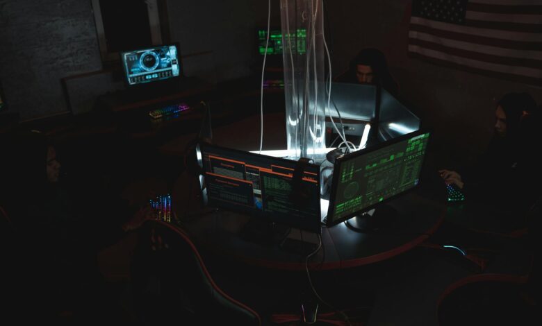 Team of cybersecurity experts collaboratively working on data protection in a dimly lit room filled with computers.