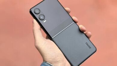 Close-up of a hand holding a modern black flip smartphone, ideal for tech and lifestyle concepts.