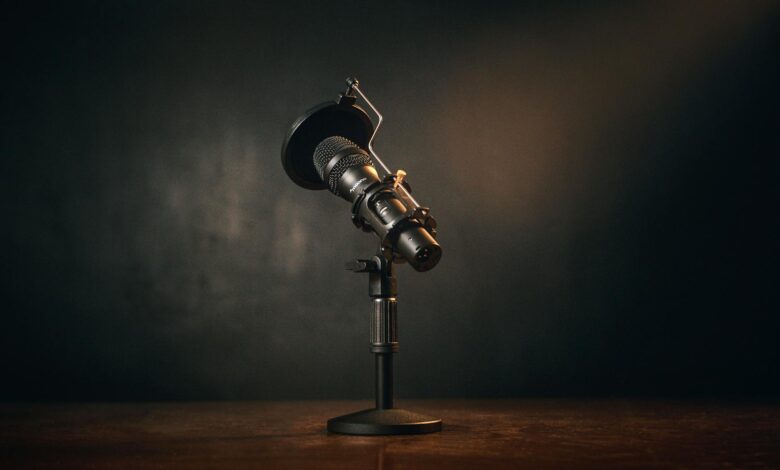 Close-up of a professional microphone setup in a dimly lit recording studio.
