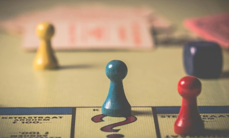 Close-up of a classic board game with vibrant tokens and dice on a playing board.