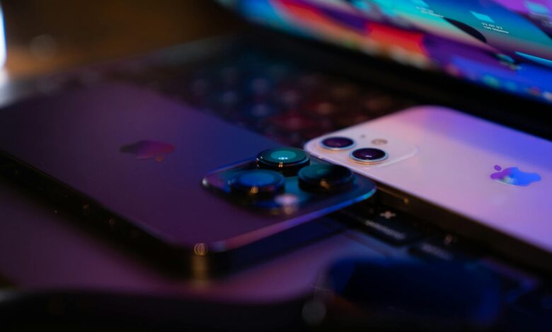 Close-up image of two modern smartphones placed on a laptop keyboard, highlighting technology design.