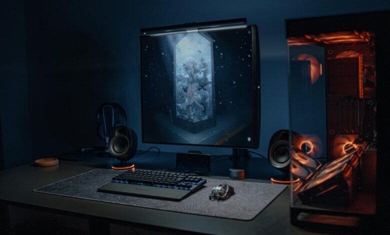A stylish gaming setup featuring a screen, keyboard, and PC with ambient lighting.