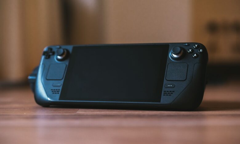 Modern handheld gaming console with buttons and joystick on a wooden surface, ideal for portable gaming enthusiasts.