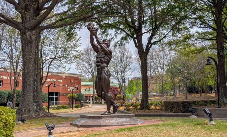 Statue at MLK Jr. Historical Park, Atlanta, surrounded by spring foliage.