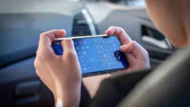A teenager plays a mobile game while sitting inside a car, showcasing modern technology engagement.