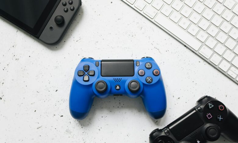 Top view of various gaming controllers and a keyboard on a white surface.