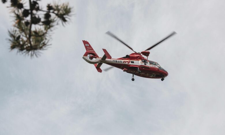 Red and white rescue helicopter flying in the sky, captured outdoors.
