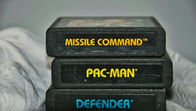 Close-up of vintage Atari game cartridges for Missile Command, Pac-Man, and Defender.