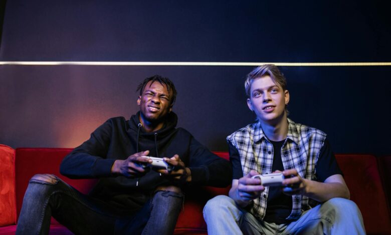 Two young men enjoying video games together on a couch, capturing leisure and friendship.
