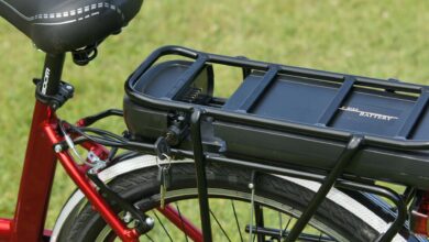 Detailed view of an electric bicycle battery mounted on a rear rack, highlighting the key-lock mechanism.