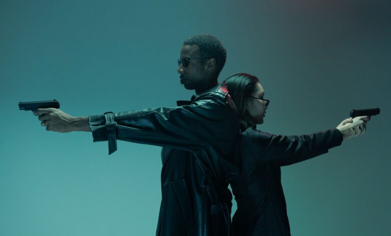 Two adults back-to-back, holding handguns, in a conceptual cyberpunk-like setting with cool tones.