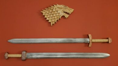 Two swords and a dragon plaque on a red wall create a medieval decor.