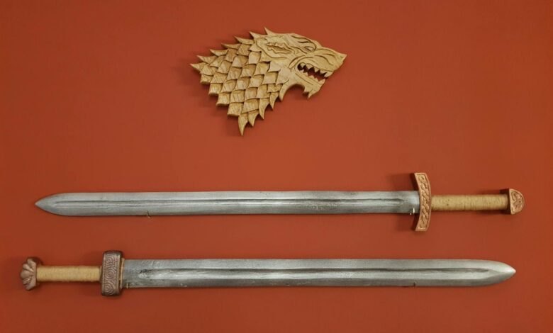 Two swords and a dragon plaque on a red wall create a medieval decor.