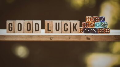 Wooden blocks spelling 'Good Luck' with colorful dice on a wooden surface.
