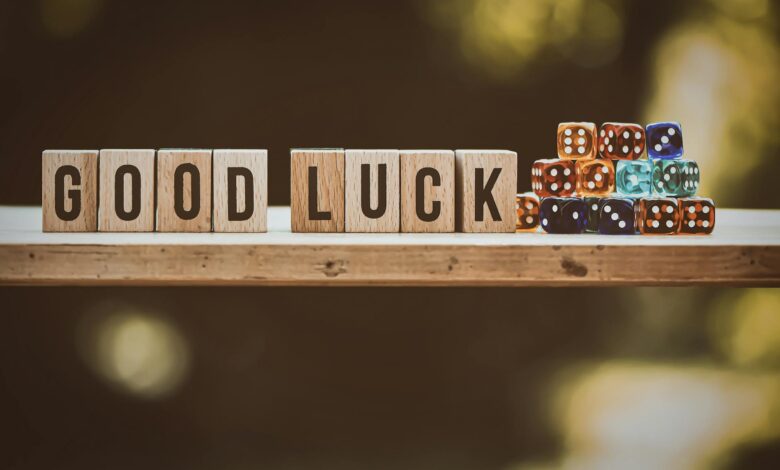 Wooden blocks spelling 'Good Luck' with colorful dice on a wooden surface.