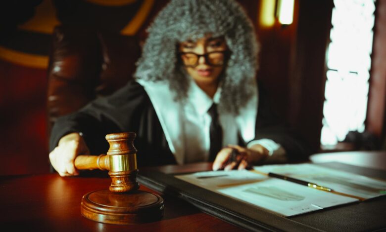 Female judge in a courtroom setting, focusing on legal documents with a gavel.