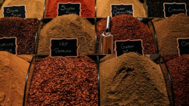 Overhead view of dry multi colored set of seasoning in lidless transparent boxes in marketplace