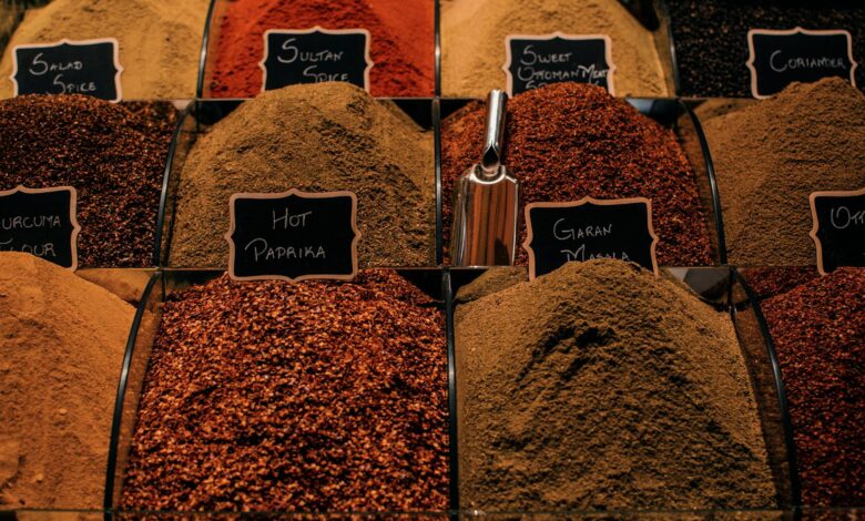 Overhead view of dry multi colored set of seasoning in lidless transparent boxes in marketplace