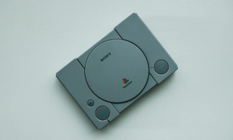 Close-up of a vintage Sony PlayStation console on a white background, highlighting retro gaming vibes.