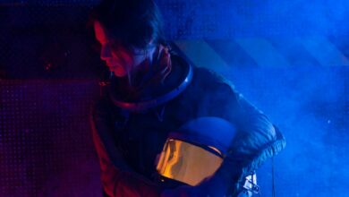 A futuristic portrait of a female astronaut holding her helmet in a dramatic blue light setting.